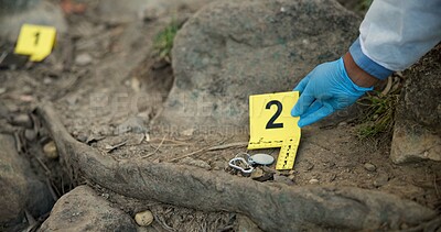 Hands, evidence marker and csi for investigation at crime scene with keys in ground or hazmat for safety in forest. Location quarantine, expert investigator or case research with observation in woods