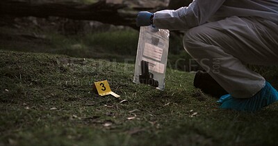 Crime scene, gun and investigator with evidence outdoor for forensics, analysis and investigation in forest or nature. Person hands with weapon, ppe and inspection or police search for clues in woods
