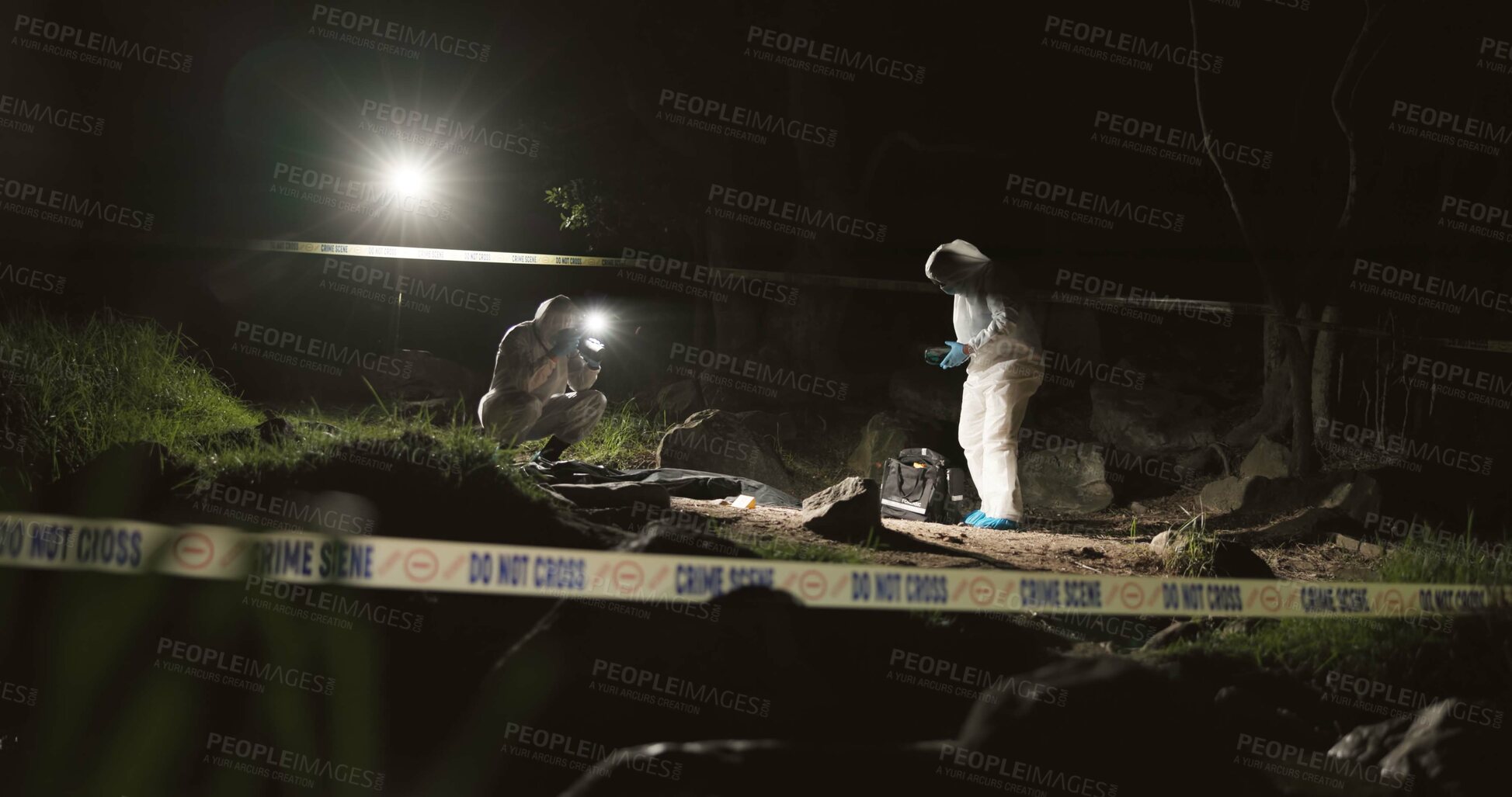 Buy stock photo Forensic team, photographer and crime scene at night for investigation or observation with hazmat or police tape. Collaboration, expert investigator or outdoor in forest for evidence or case research