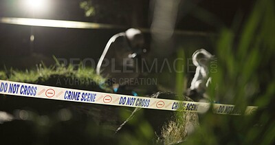 Crime scene, photography and investigator with evidence outdoor for analysis and investigation in forest or nature. People, detective or forensic photographer at night inspection with tape in woods