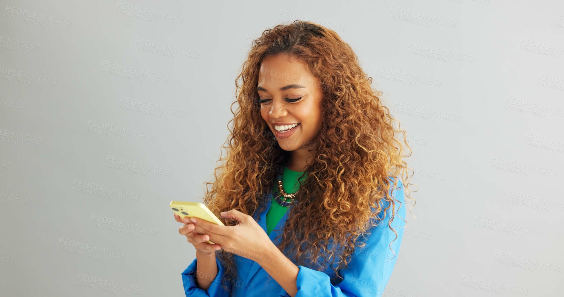Buy stock photo Happy woman, typing and networking with phone for social media or communication on a gray studio background. Female person or model with smile on mobile smartphone for online chatting on mockup space