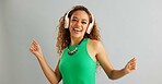 Happy woman, dancing and listening with headphones to music or sound on a gray studio background. Excited female person or model enjoying audio podcast, energy or vibe with headset on mockup space