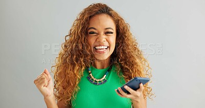 Excited woman, winner and phone with good news for lottery, prize or promotion on a gray studio background. Happy female person dancing with smile and mobile smartphone for celebration or success