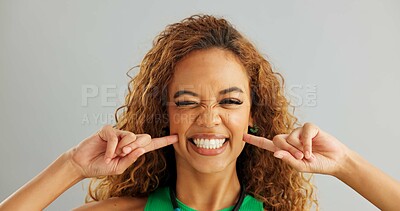 Woman, funny face and studio with goofy comedy on grey background or humor mockup space, silly or joking. Female person, model and comic emoji expression with tongue out, peace sign or hand gesture