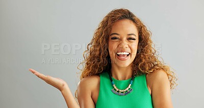 Happy woman, palm and advertising with choice for marketing or option on a gray studio background. Portrait of female person or model with smile or hand out for selection or pick on mockup space