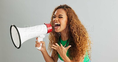 Happy woman, shouting and pointing with megaphone for motivation on a gray studio background. Excited female person screaming with bullhorn in winning, celebration or announcement for choice or pick