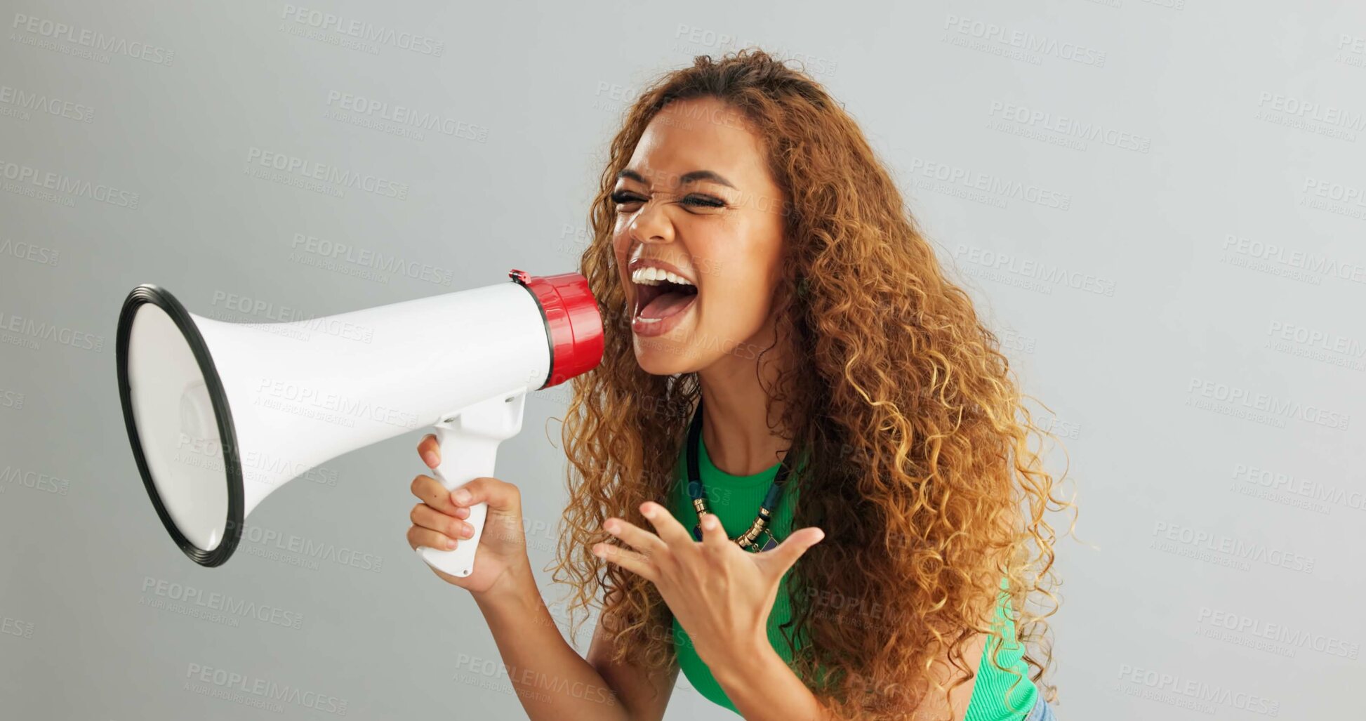 Buy stock photo Happy woman, shouting and pointing with megaphone for motivation on a gray studio background. Excited female person screaming with bullhorn in winning, celebration or announcement for choice or pick