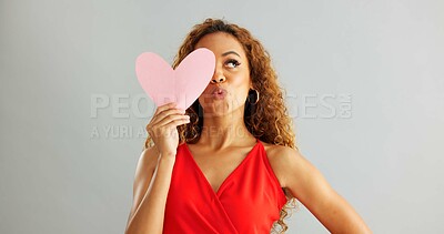 Woman, love and kiss face with paper heart for opinion, romance or thinking with ideas on grey background. Face, emoji and female person with happiness for kindness, vote or support on valentines day