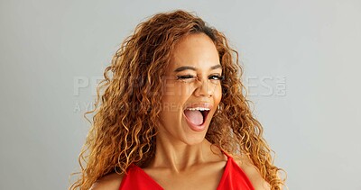 Happy woman person, wink and laughing in studio, excited and flirt on grey background. Cheerful, joyful and smile on female model face, friendly and natural with curly hair of fun African Lady