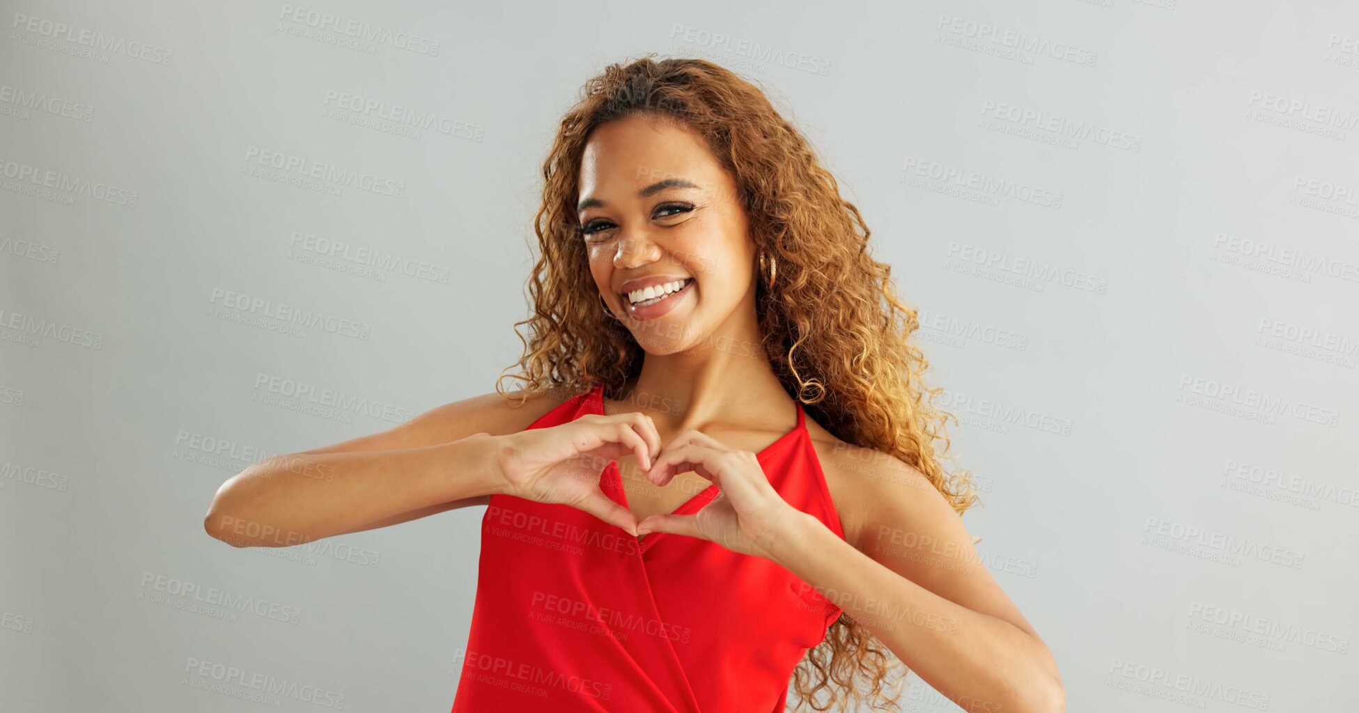 Buy stock photo Happy woman, love and support with heart hands for romance or care on a gray studio background. Portrait of female person or model with smile, like emoji or shape for valentines day on mockup space