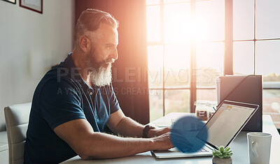 Buy stock photo Cropped shot of a handsome mature businessman working on his laptop in the office