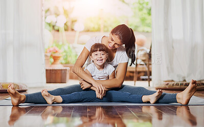 Buy stock photo Portrait of a cheerful young mother and daughter doing a yoga pose together while holding each other in a spit position