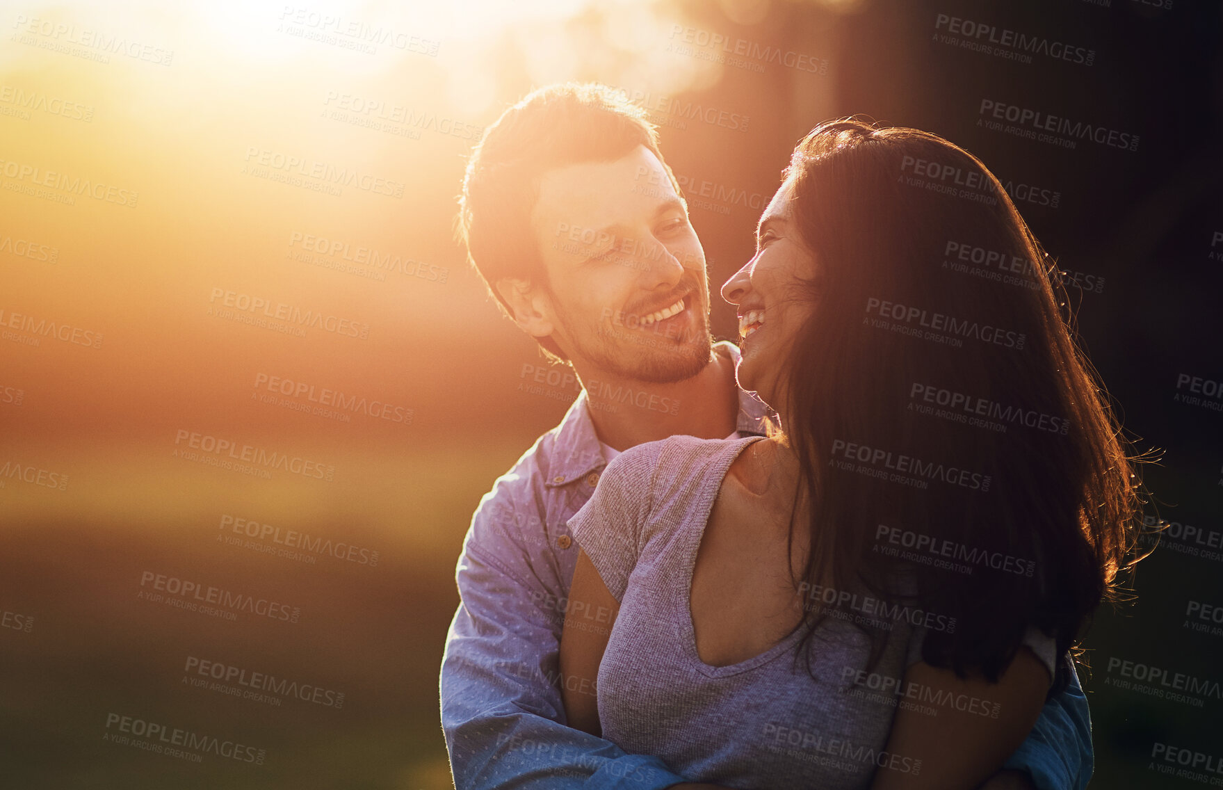 Buy stock photo Date, hug and happy couple outdoor at sunset for love, care and bonding together at park. Laughing, man and woman embrace at garden for conversation, support and joke for relationship on vacation