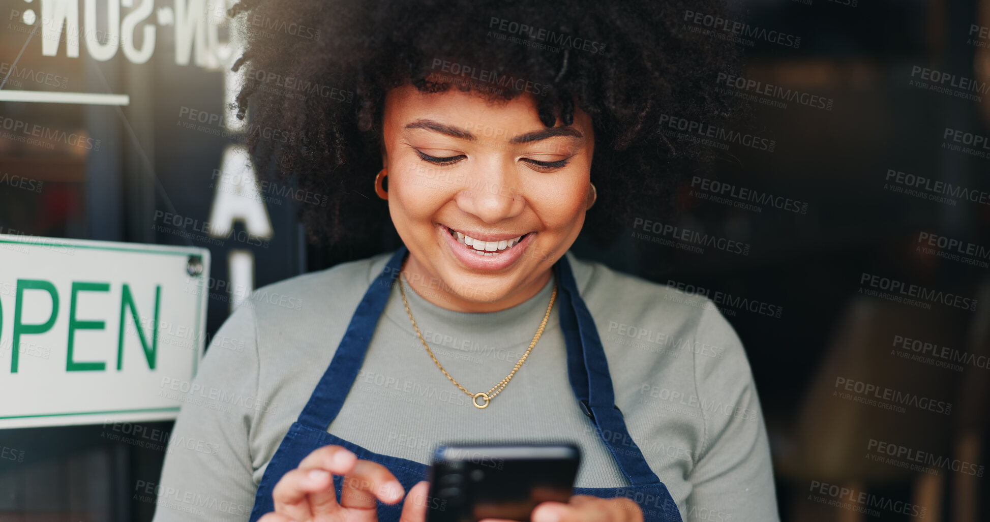 Buy stock photo Black woman, phone and open cafe by door for communication, social media or networking. Happy African female person or waitress smile on mobile smartphone in online chatting or texting at coffee shop