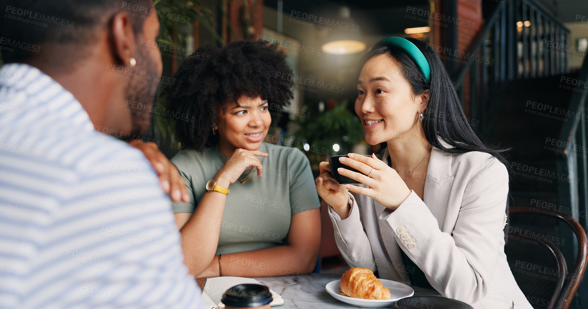 Buy stock photo People, friends and laughing with coffee at cafe for funny joke, discussion or break together. Happy group smile enjoying fun conversation with beverage, croissant or cup of tea at indoor restaurant