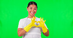 Happy asian woman, heart hands and green screen in housekeeping against a studio background. Portrait of female person, maid or cleaner smile or show loving hand emoji, sign or symbol on mockup space