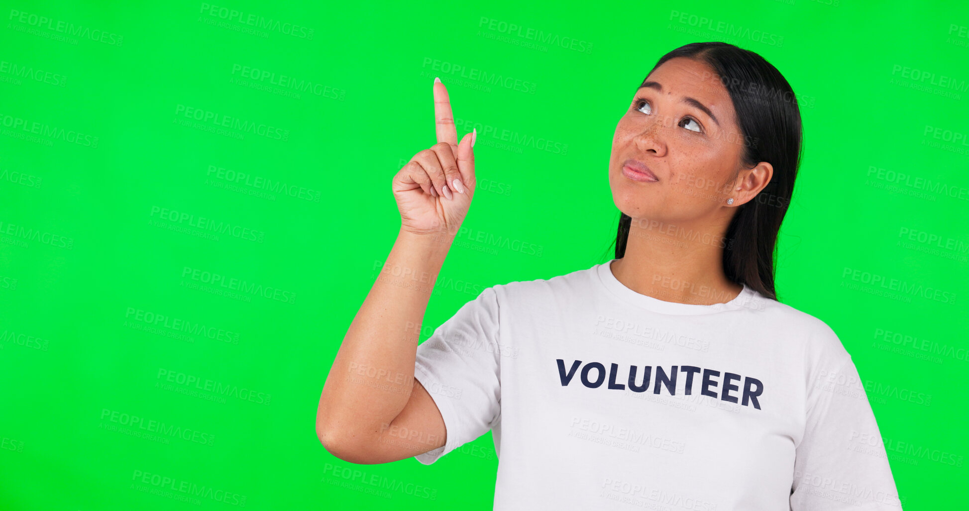 Buy stock photo Pointing, volunteer and Asian woman on green screen for charity announcement, news and information. NGO, mockup and person with hand gesture for non profit, community service and help in studio