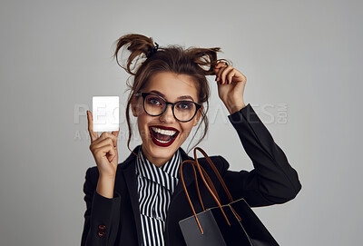 Portrait, business card and woman with shopping bags, excited and customer on grey studio background. Face, person and model with mockup space, punk rock and edgy outfit with girl, edgy and promotion