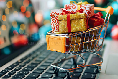 Christmas gifts, shopping cart and miniature on laptop for celebration, festive season or religious holiday. Closeup, presents and trolley on computer for xmas, surprise and wrapping paper with bokeh