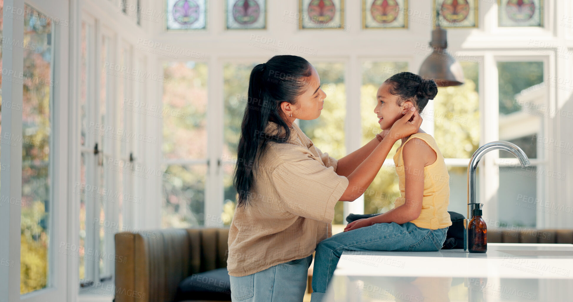 Buy stock photo Mother, daughter and getting ready in kitchen or home with backpack, ear check and greeting. Morning, girl child and mom with prepare for education, learning and school with love, care and helping