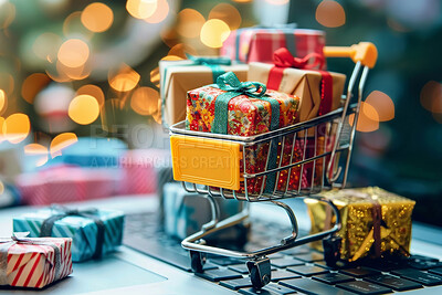 Buy stock photo Christmas, shopping cart and miniature gifts on laptop for ecommerce, festive season or religious holiday. Closeup, presents and trolley on computer for xmas, surprise and wrapping paper with bokeh