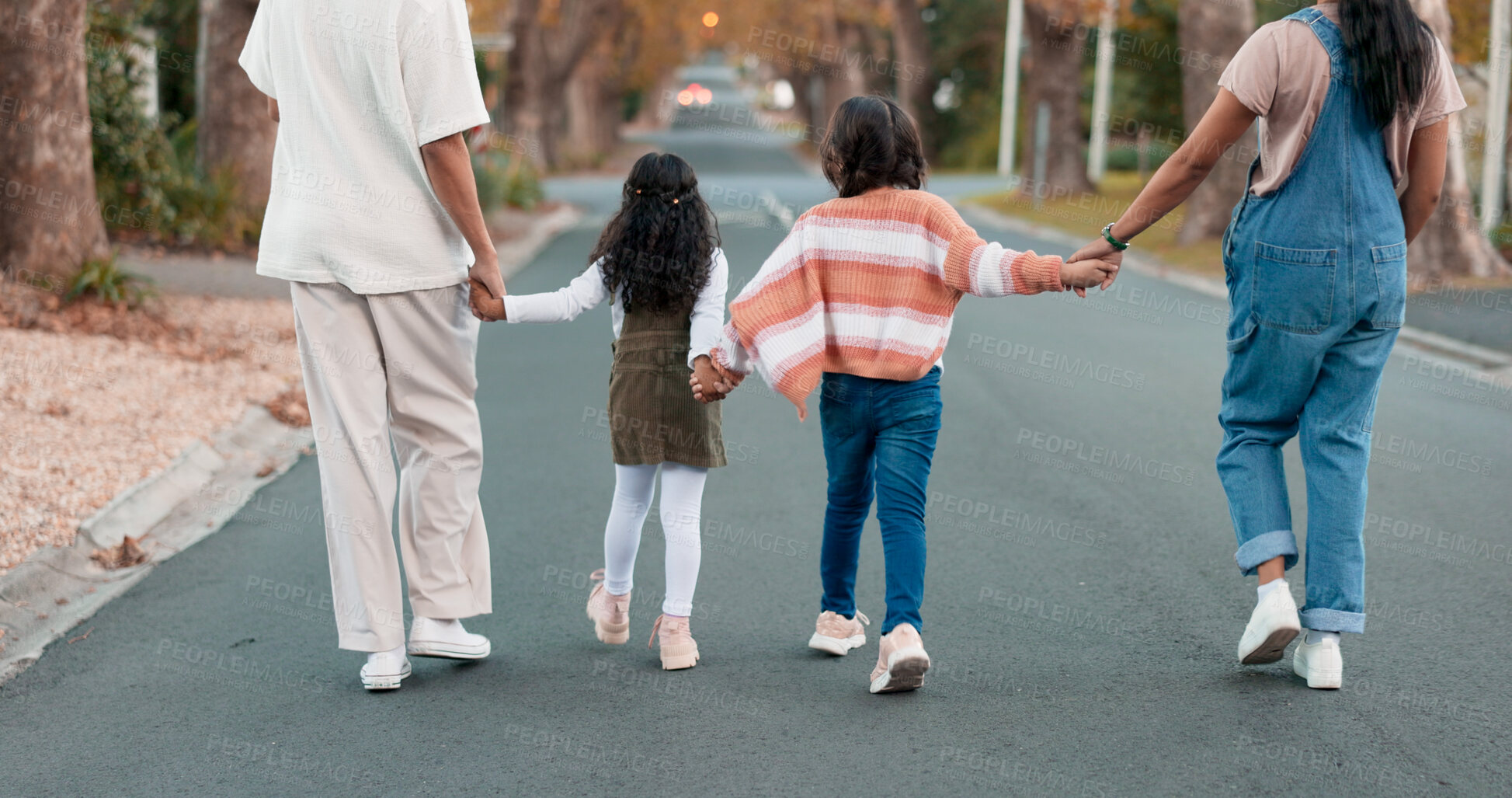 Buy stock photo Walking, street and parents holding hands with children in neighborhood for adventure, journey and trip to park. Family, suburbs and back of mom, dad and kids in road for bonding, fun and relax