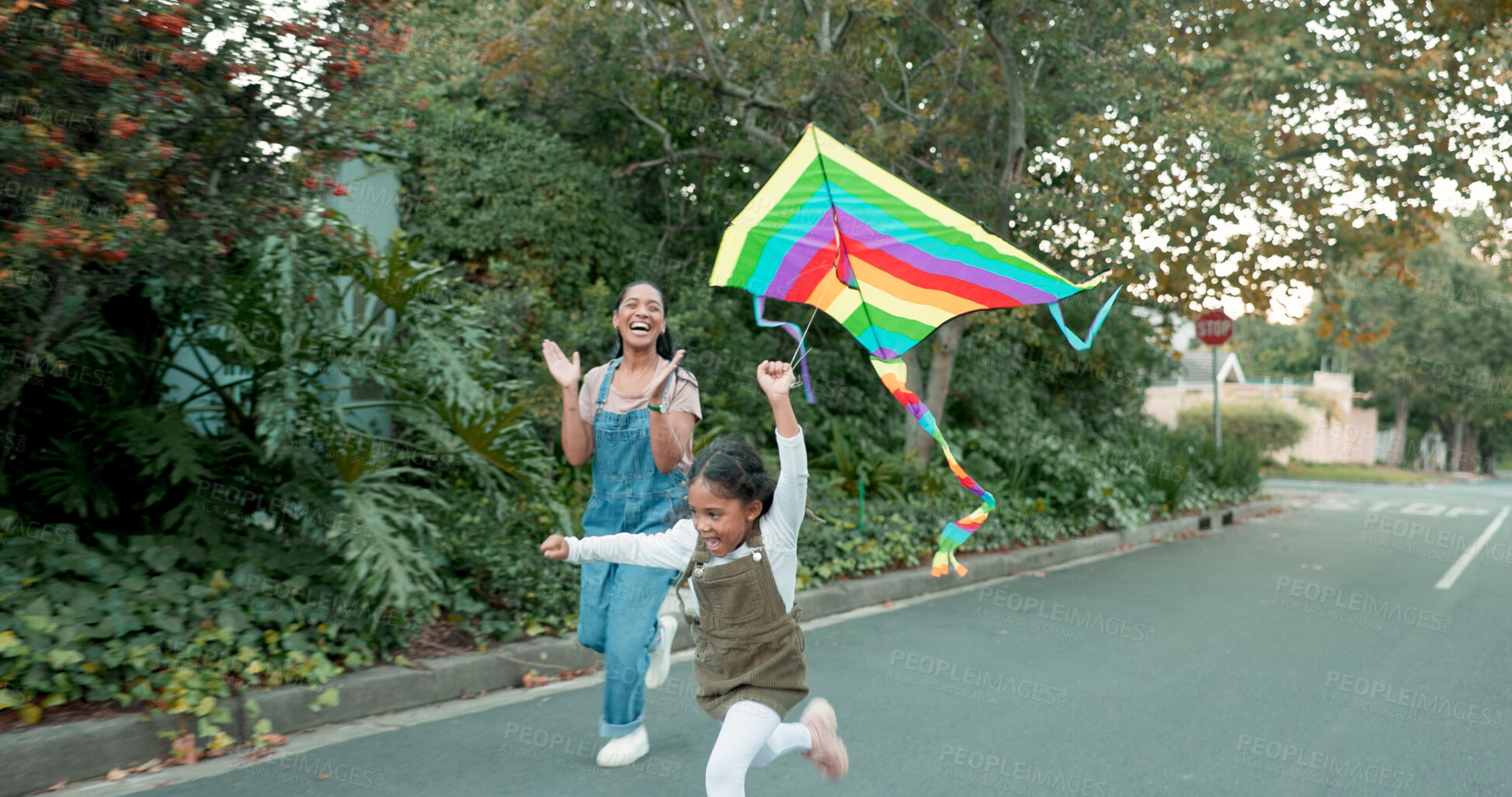 Buy stock photo Playing, flying a kite and girl with her mother together outdoor in street with support, applause or fun game. Kid, love or woman running with excited daughter in neighbourhood for adventure or pride