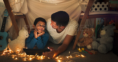 Dad and son at night on tablet in tent watching movies, online games and cartoon with fairy lights. Happy family, blanket and father with boy in bedroom on digital tech for bonding, relax and love