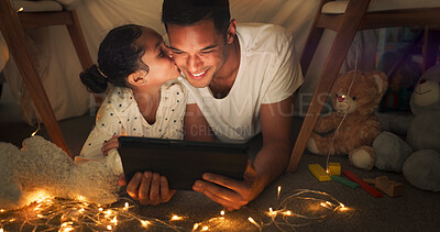 Happy, tablet and child kiss father in a tent house streaming internet video, show or movie online and bonding at night. Dark, digital and parent or dad relax with kid watching comedy in the evening