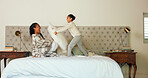 Happy, bedroom and mother tickling her child with love, care and playful expression at their home. Happiness, smile and young mom playing and bonding with her girl kid on a bed in their family house.