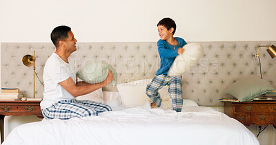 Playful, pillow fight and father and child in the bedroom for bonding, morning fun or playing together. Happy, family and young dad fighting with a kid and pillows on the bed of a house and laughing