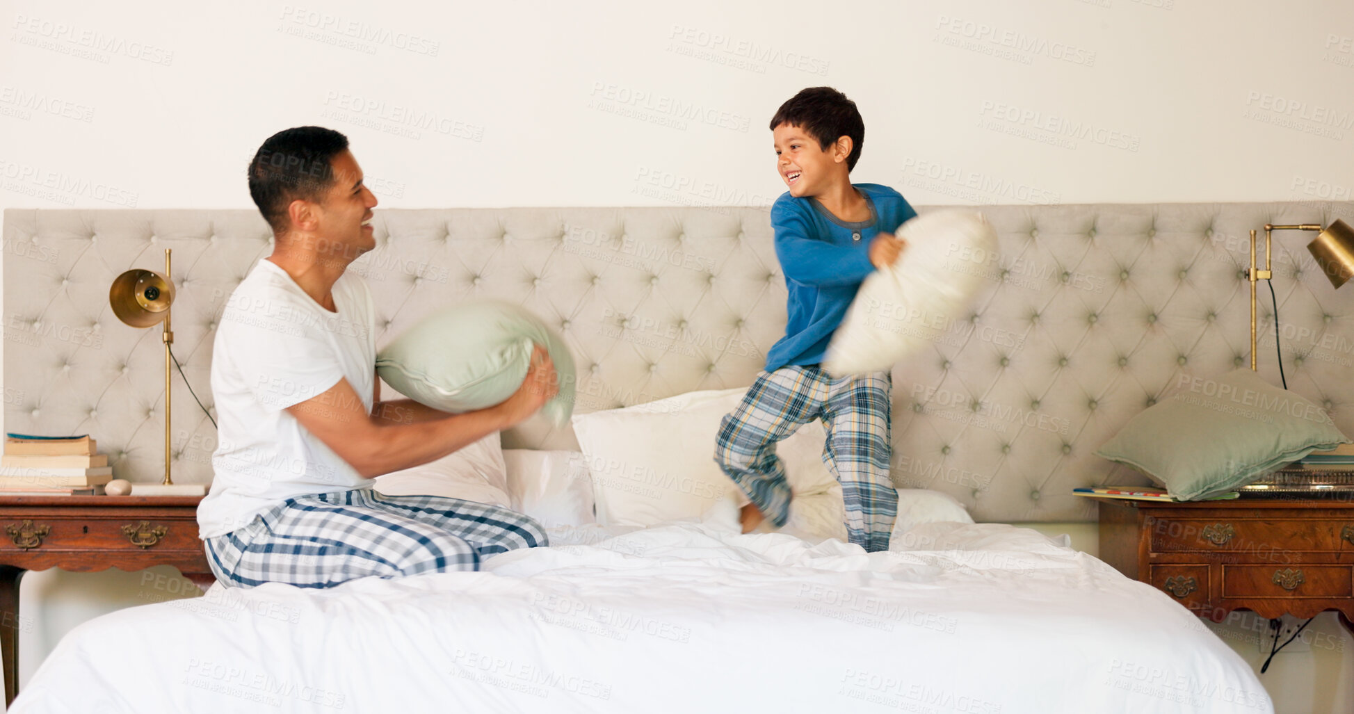 Buy stock photo Father, son and pillow fight or playing in bedroom for bonding, morning fun and childhood memory on bed. Happy, family and dad with kid for fighting game, laughing, and energy on holiday or weekend