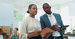 Business man, woman and notes at glass with tablet, discussion and planning with teamwork in office. People, partnership and digital touchscreen by board with reading, thinking and creativity at job