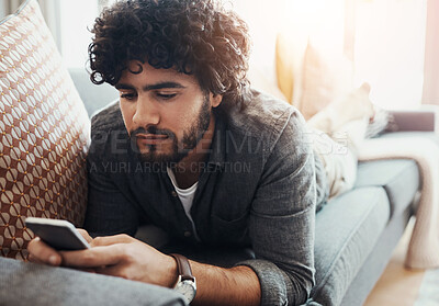 Buy stock photo Home, relax and man with phone on sofa for social network, communication and digital connection. Calm, and male person with tech in living room for sports news, information and reading online results