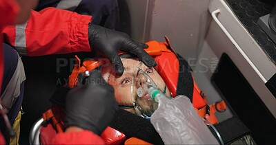 Man, patient and paramedic in first aid with flashlight, eyes and emergency with medicine and injured. Victim, accident and ems of 911 with oxygen mask, medical service and healthcare to hospital
