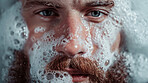 Bubbles, beard and face of man in bath for clean, health and skincare routine with body hygiene. Foam, portrait and male person with facial hair washing in water for wellness treatment at home.