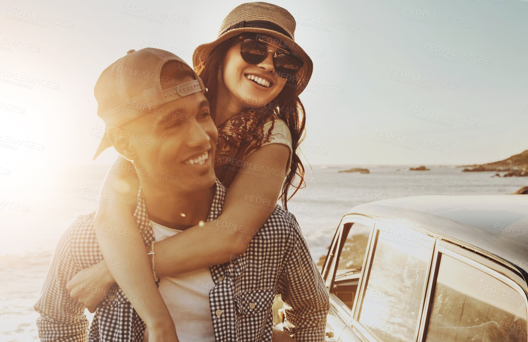 Buy stock photo Couple, sunset and piggy back at beach with care, smile and road trip for holiday adventure in summer. Man, woman and happy with connection, travel and love for bonding in sunshine by ocean in Spain