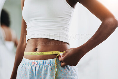 Buy stock photo Closeup shot of an unrecognizable woman measuring her waist