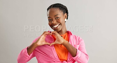Happy, black woman and heart hands with love for care, support or romance on a gray studio background. Portrait of African female person with smile, like emoji or shape for romantic gesture on mockup