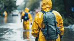 People, street or rescue in flood, natural disaster or climate change by global warming in city. Road, water or ppe in safety, gear or rain coat as help, support or protection by monsoon tsunami