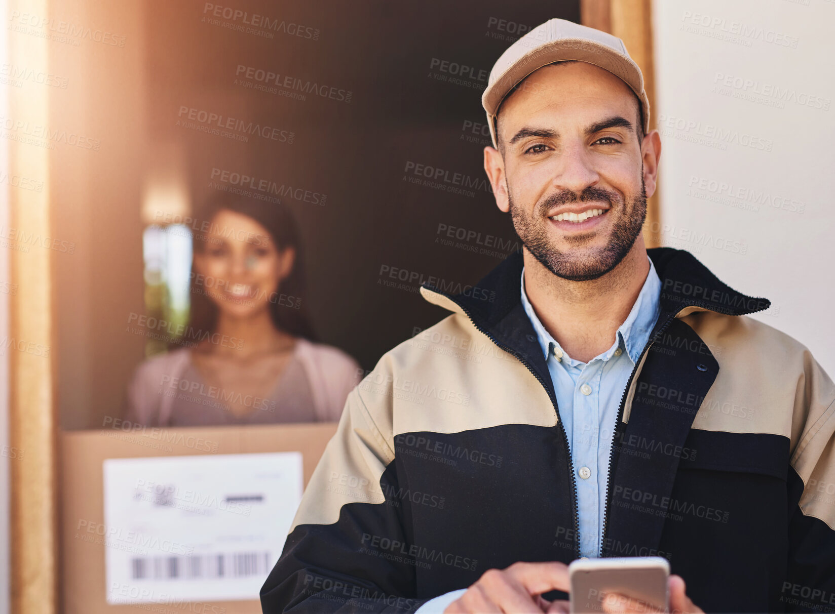 Buy stock photo Portrait of a courier using a cellphone while making a delivery to a customer