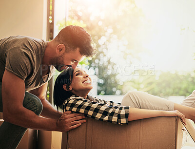 Buy stock photo New home, smile and couple pushing box, having fun and bonding in apartment. Real estate, happiness and man and woman in cardboard, play and enjoying quality time together while moving into property.