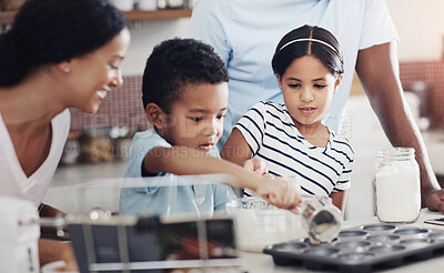 Buy stock photo Cropped shot of a young family baking together in the kitchen at home