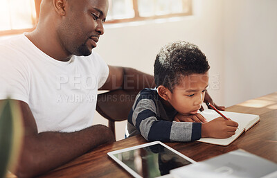 Buy stock photo Cropped shot of a handsome young father helping his son with some homework