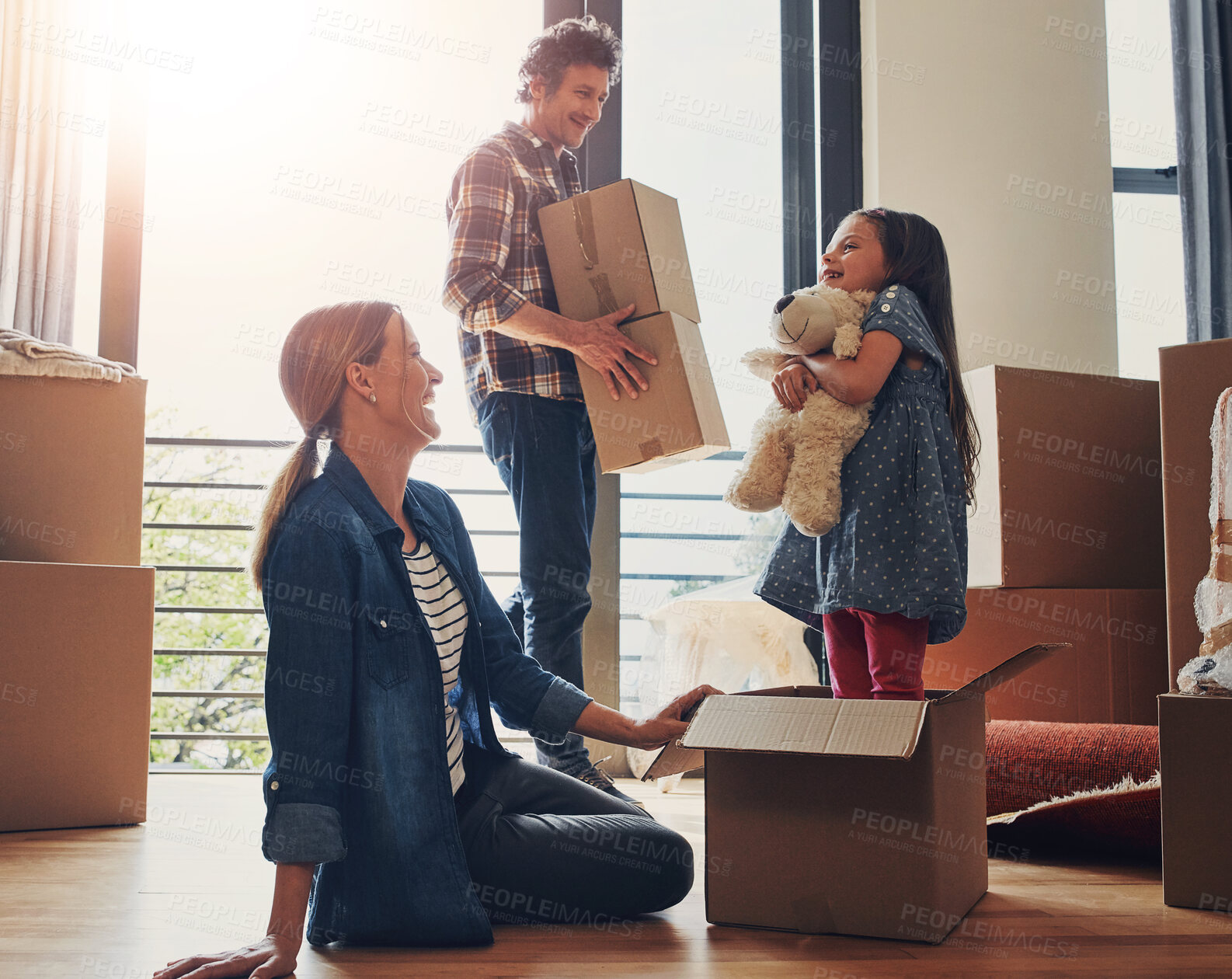 Buy stock photo Moving, boxes and parents with child in new home bonding together for family time with teddy bear. Happy, mortgage and girl kid play with mom and dad for fun and unpacking cardboard package for house