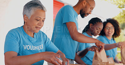 People volunteering, packaging food and donation for community service, poverty support and NGO management. Nonprofit, senior woman or group with groceries, helping outdoor or team in charity project