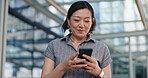 Woman, texting and commute to work, city and smartphone, conversation and technology. Happy, japanese and check email in urban area, office buildings and businesswoman for networking and chat