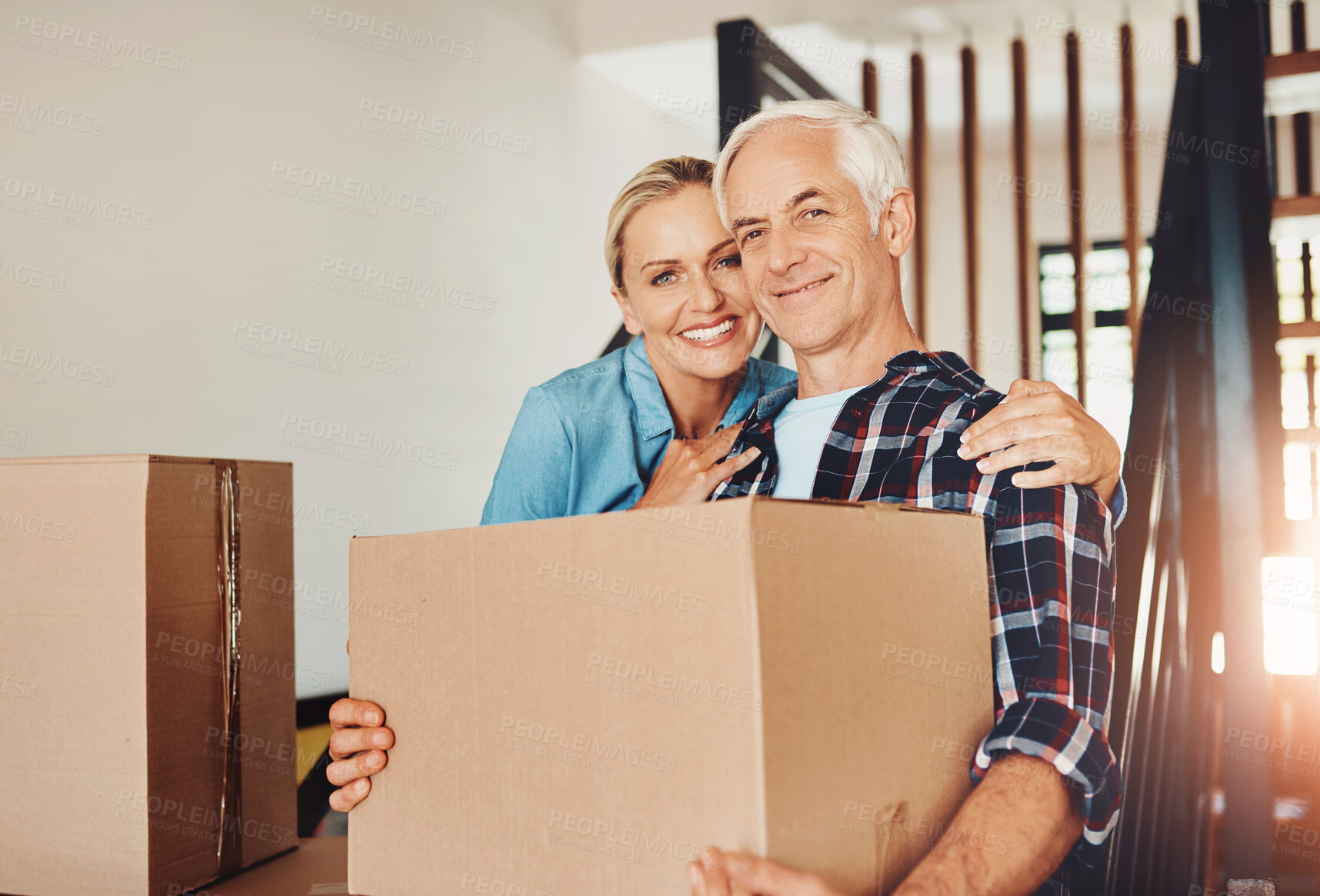 Buy stock photo Mature couple, moving and portrait in new home with hug, help and pride for immigration at property. People, woman and man with cardboard container, relocation and investment in real estate in Spain