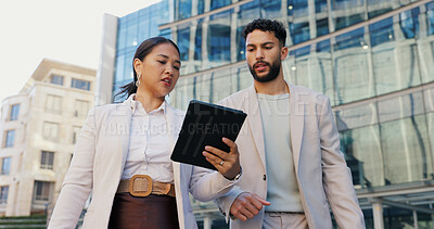 Business people, discussion and talking with tablet in city for research, browsing or outdoor networking. Businessman and woman discussing project, idea or online tasks on technology in an urban town