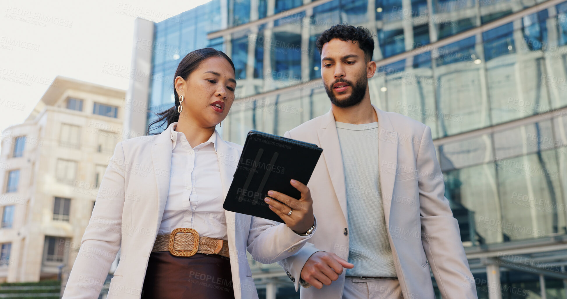 Buy stock photo Business people, discussion and talking with tablet in city for research, browsing or outdoor networking. Businessman and woman discussing project, idea or online tasks on technology in an urban town